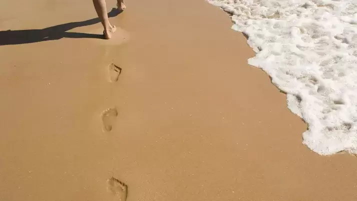 ślady stóp na piaszczystym brzegu